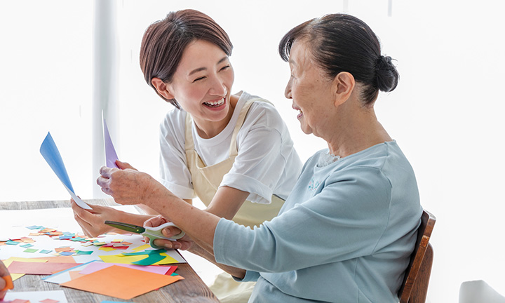 入居者と折り紙を折る職員